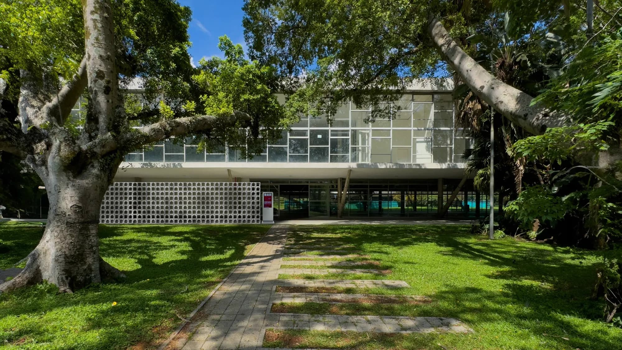 Fachada do Pavilhão das Culturas Brasileiras durante a BAB 2026, entre árvores do Parque Ibirapuera